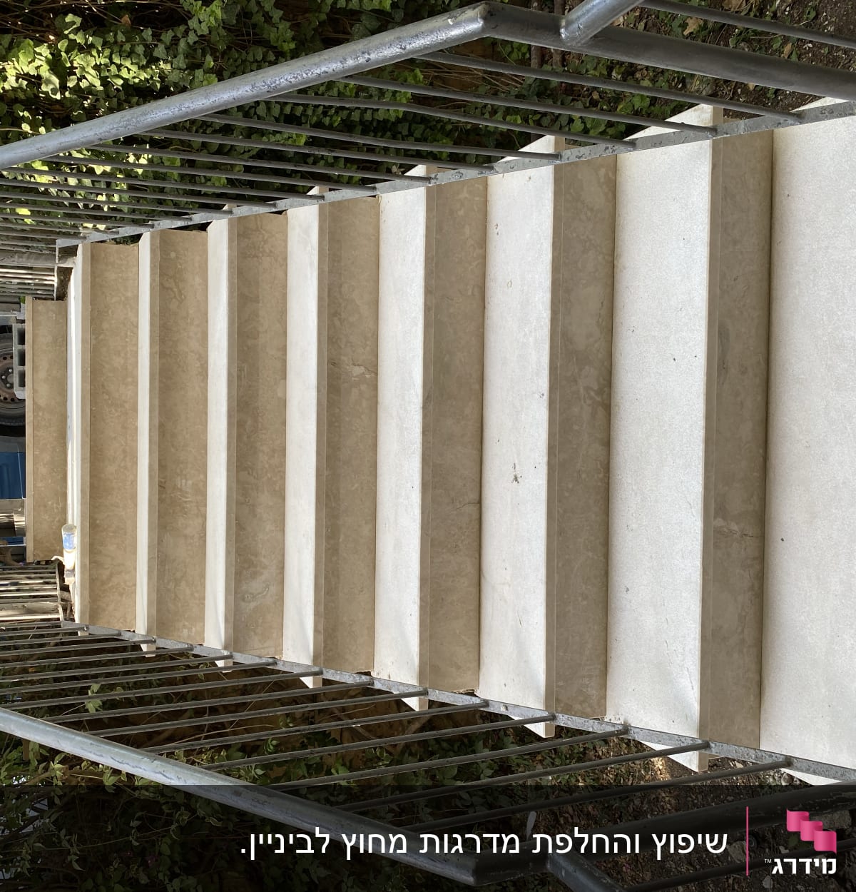 מדרגות שיש עם מעקה מתכת בשיפוץ